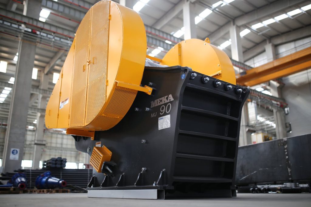 High-angle image of a jaw crusher machine inside a modern industrial manufacturing plant.